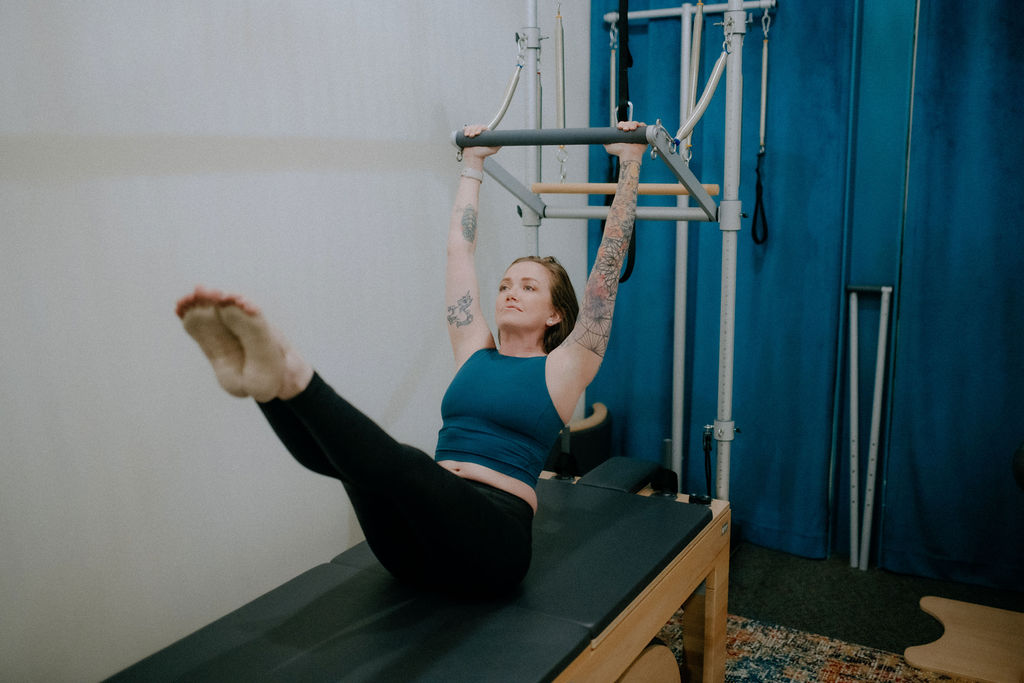 woman completing Teaser Pilates Exercise on Pilates Cadillac equipment